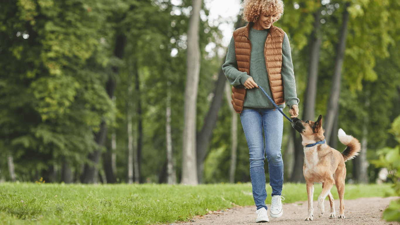vrouw kniepijnvrij laat haar hondje uit