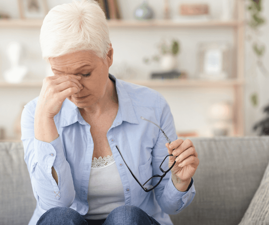 vrouw voelt naar de druk aan haar ogen omdat ze fibromyalgie heeft.